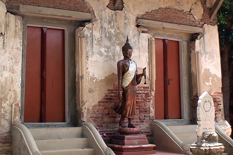 Buddha Image in front of the old, abandoned Ubosoth